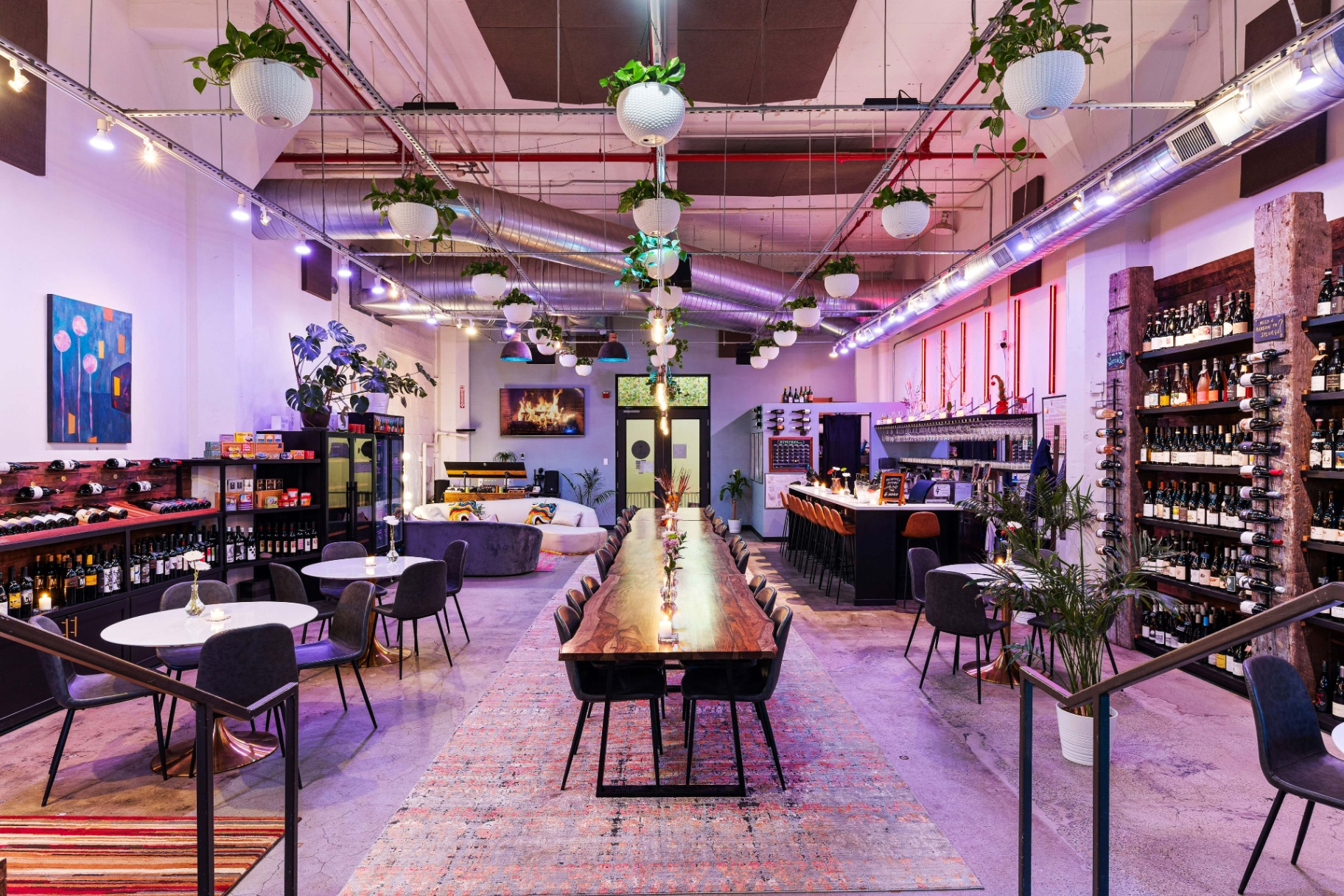 Backcountry event space — long communal table, bar, and lounge under string lights inside the historic Ford Building.