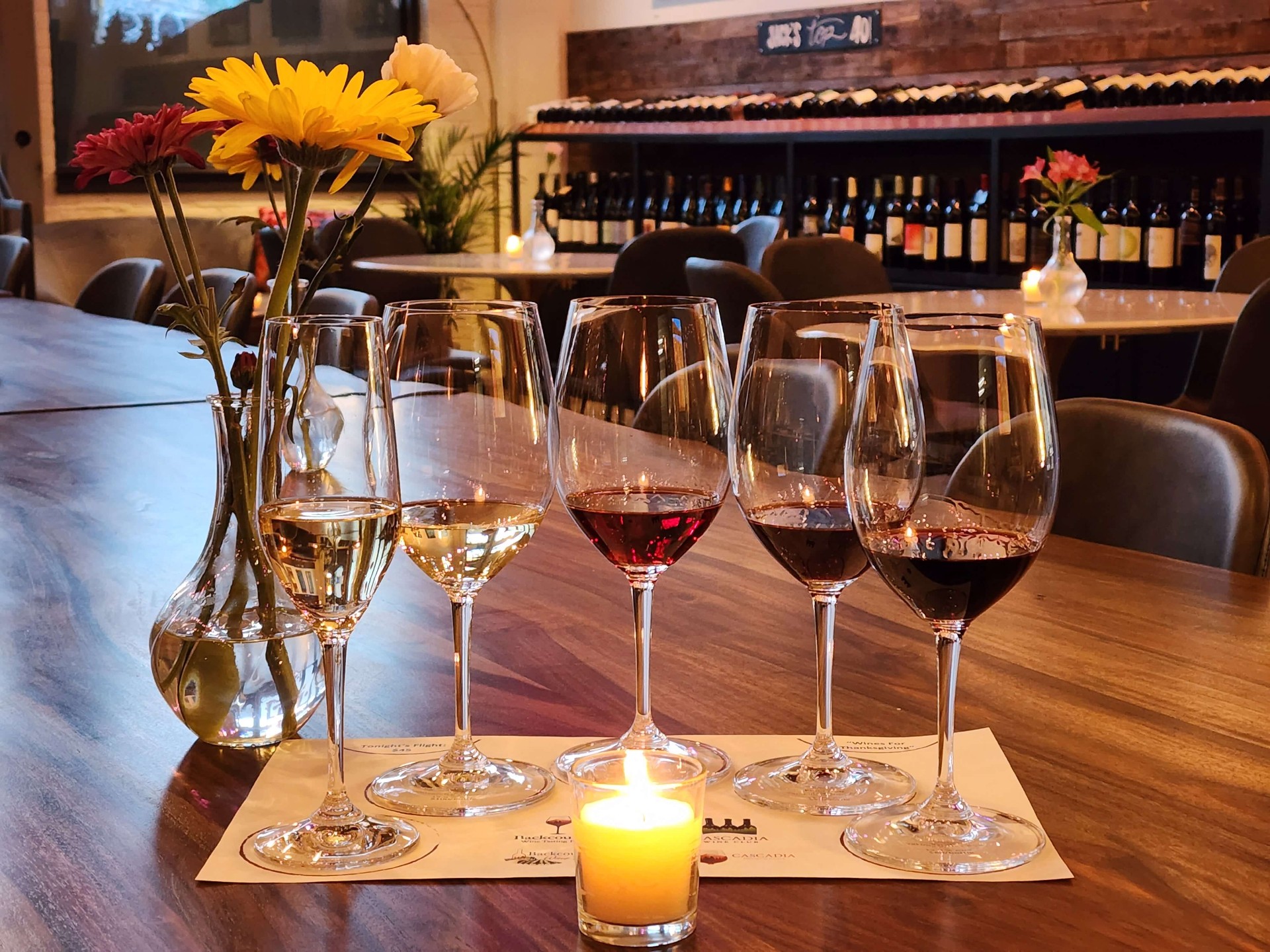 Five-glass tasting flight on the live-edge communal table.